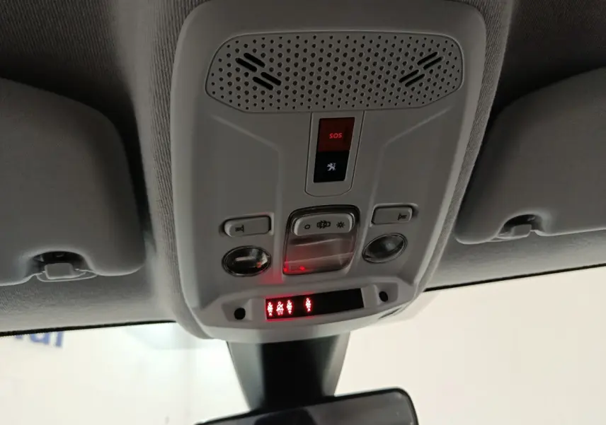 Vue en contre-plongée du plafonnier gris clair avec commandes SOS et éclairage intérieur du Peugeot 208 blanc de 2020