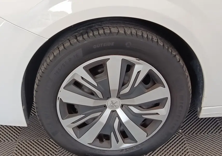 Gros plan sur la roue avant gauche blanche d'une Peugeot 208 PureTech 100 S&S Active Business 2020.