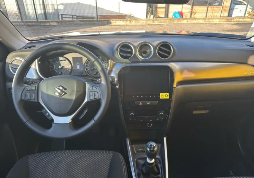 Intérieur du Suzuki Vitara Hybrid 110 Privilege AllGrip 2025, vue frontale sur le tableau de bord noir avec volant cuir multifonctions.