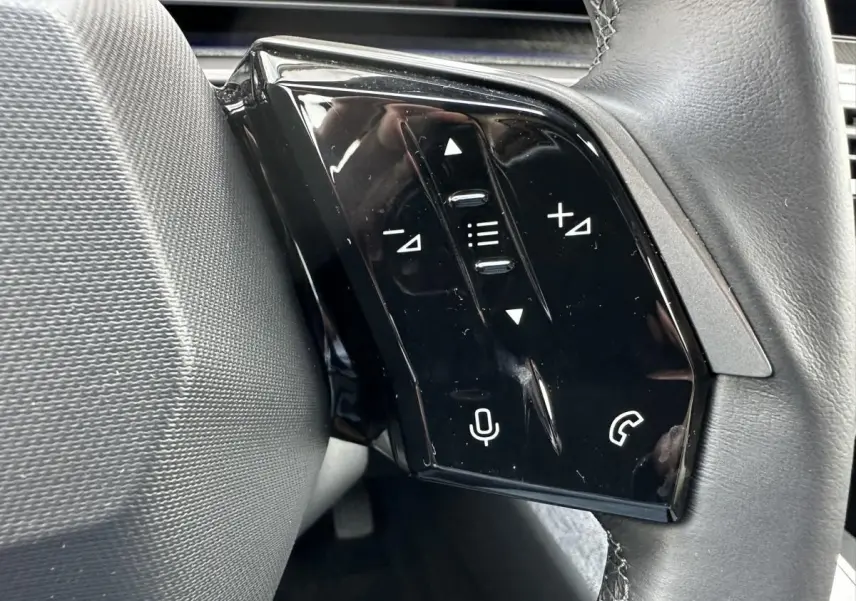 Gros plan sur les commandes tactiles noires à gauche du volant du Peugeot 3008 2024 gris Artense.