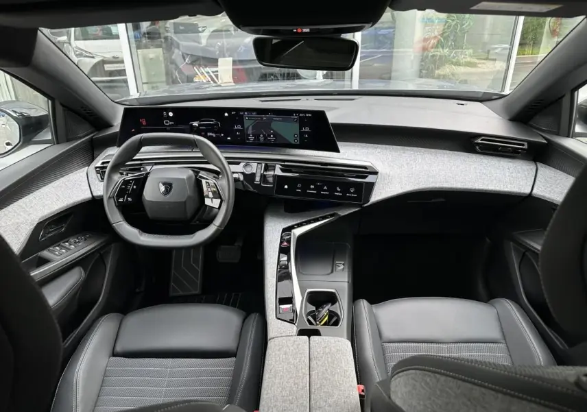 Vue intérieure avant du Peugeot 3008 2024, tableau de bord moderne avec double écran HD et volant compact noir.
