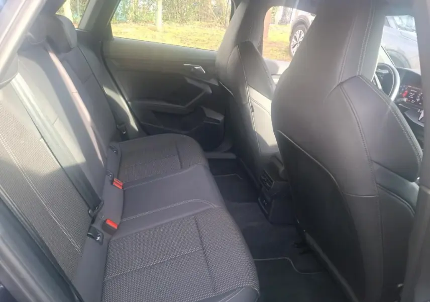 Vue intérieure arrière de l'Audi A3 2022 bleu, montrant les sièges arrière en tissu noir avec surpiqûres blanches.