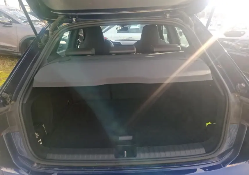 Vue arrière du coffre ouvert d'une Audi A3 2.0 TDI 150 S-TRONIC S-Line bleu, avec cache-bagages en place.