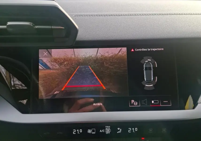 Vue intérieure du tableau de bord de l'Audi A3 bleu 2022, avec affichage caméra de recul et capteurs de stationnement.