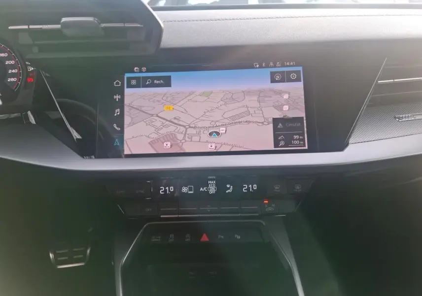 Vue rapprochée de l’écran central tactile et de la console de climatisation dans l’habitacle noir de l’Audi A3 bleu 2022.
