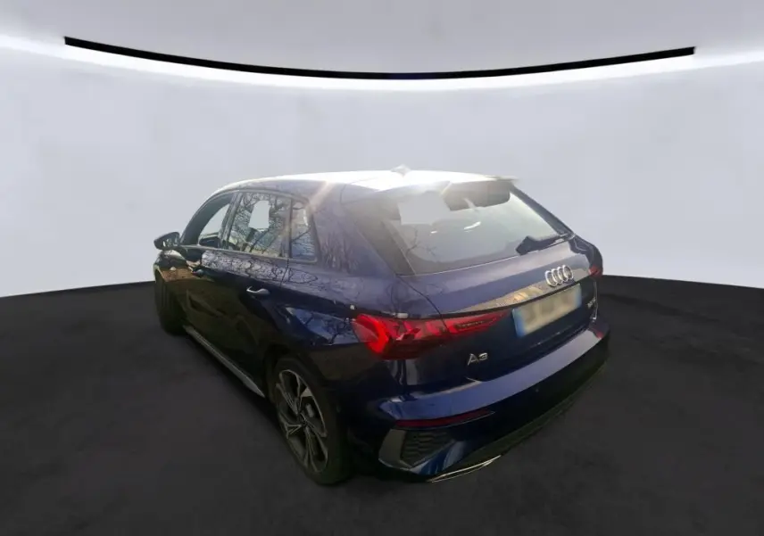 Audi A3 bleu 3/4 arrière droit, mettant en valeur les feux arrière LED et la silhouette compacte cinq portes.