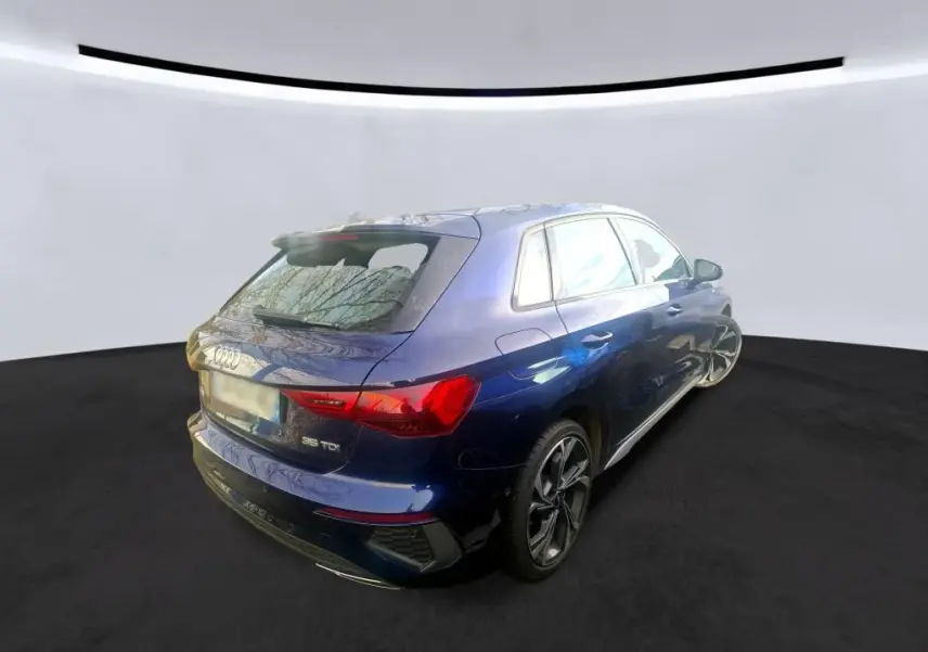 Audi A3 2.0 TDI S-Line bleu vue 3/4 arrière droit, avec jantes sport et feux arrière LED distinctifs.