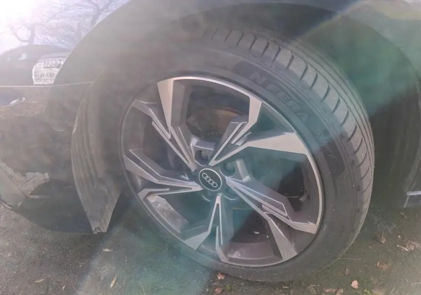 Gros plan sur la roue avant gauche d'une Audi A3 bleu 2.0 TDI 150 S-Line avec jante alliage au design moderne.