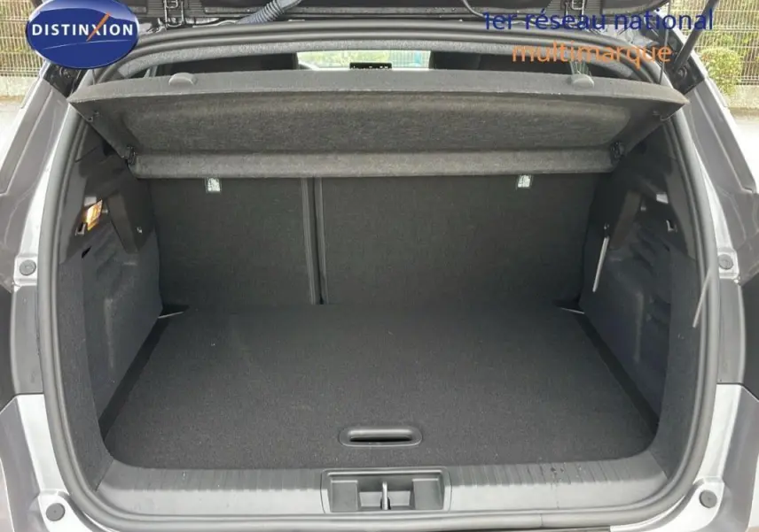 Coffre ouvert d’un Renault Captur gris 2025, vue arrière montrant l’espace de chargement et la tablette cache-bagages.