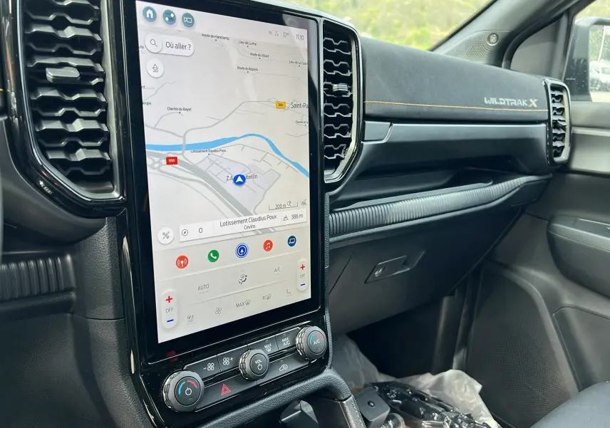 Intérieur du Ford Ranger Wildtrak X 2025 vu côté passager, tableau de bord noir avec écran tactile vertical et surpiqûres jaunes.