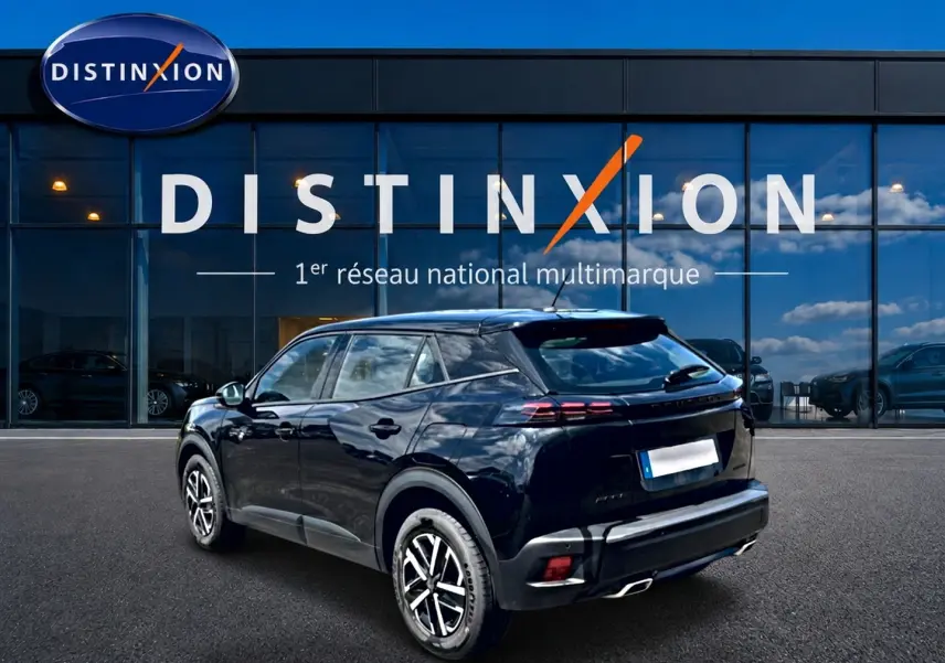 Vue 3/4 arrière droite d’un Peugeot 2008 noir 2025 avec becquet et feux arrière LED devant une vitrine Distinxion.