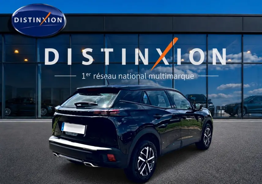 Peugeot 2008 noir vue 3/4 arrière droit, avec feux arrière LED et jantes alliage, devant vitrine Distinxion.