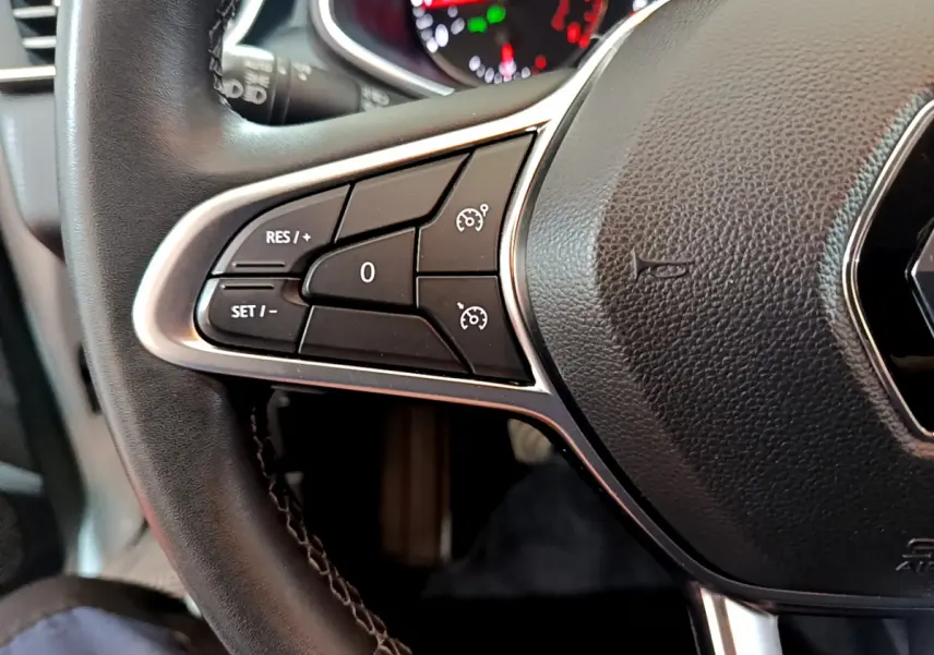 Gros plan sur le volant cuir noir de la Renault Clio Business 2021, avec commandes de régulateur de vitesse côté gauche.