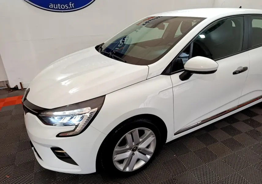 Renault Clio Business blanc vue 3/4 avant droit avec phares LED allumés et jantes alliage.