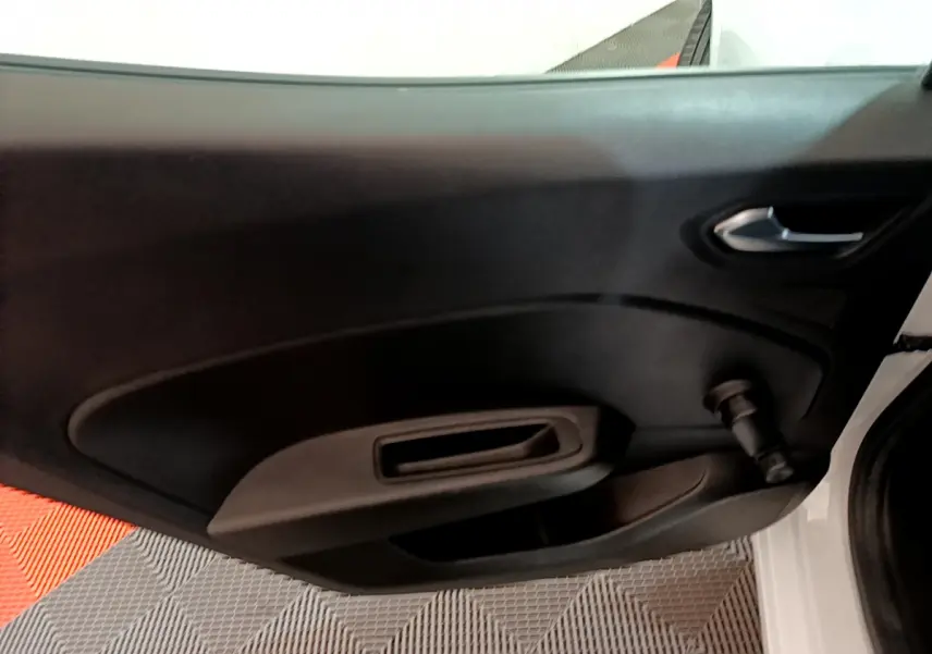 Intérieur de la porte côté gauche d'une Renault Clio Business blanche, avec poignée et manivelle de vitre manuelle.