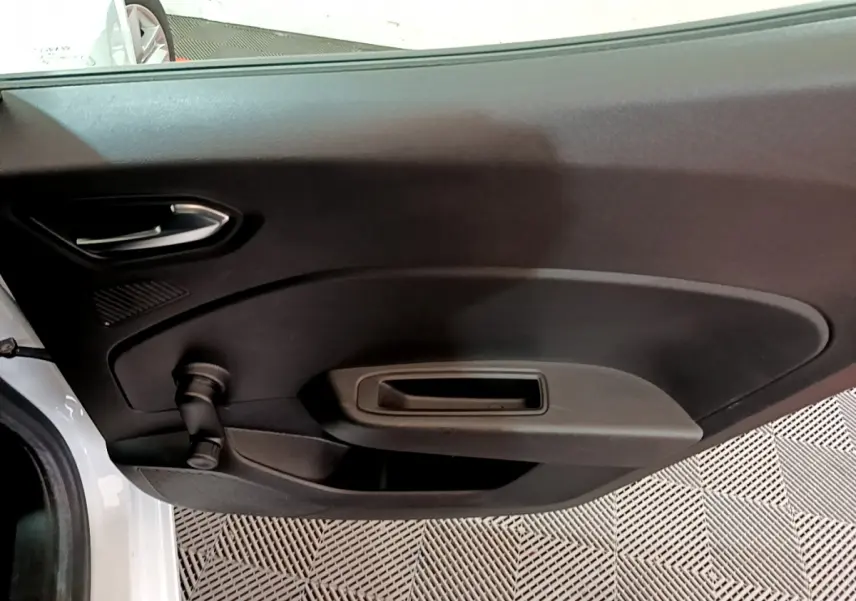 Vue rapprochée de la porte intérieure côté gauche d'une Renault Clio Business blanche avec poignée et manivelle de vitre.