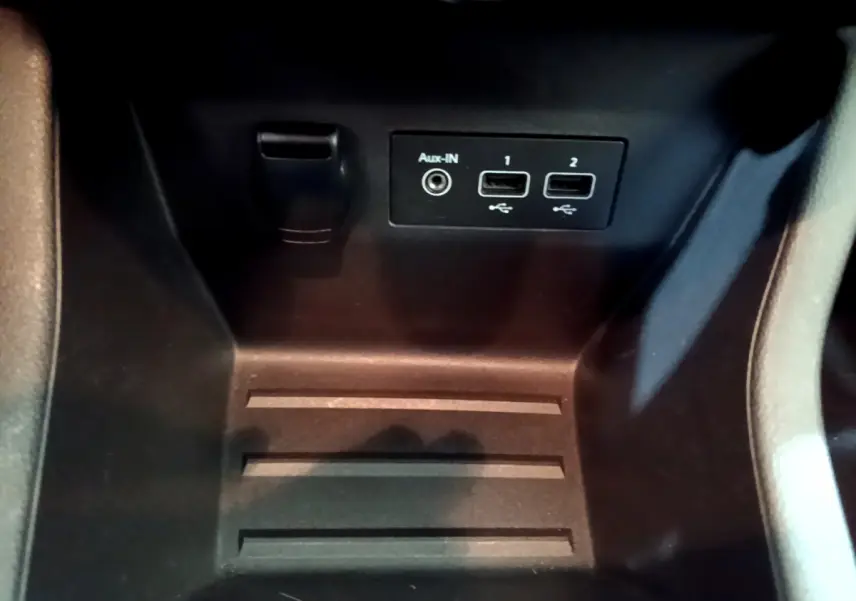 Prise auxiliaire et deux ports USB dans le rangement central d'une Renault Clio Business blanche de 2021.