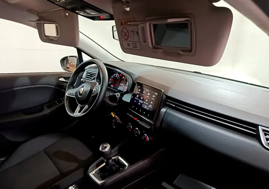 Intérieur noir de la Renault Clio Business 2021 vu côté conducteur, volant cuir et écran tactile central visible.