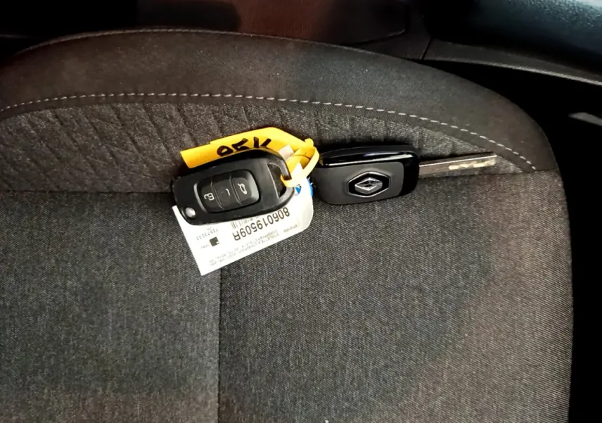 Clé Renault posée sur un siège tissu gris foncé à l'intérieur d'une Clio Business blanche 2021.