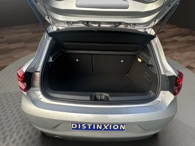 Vue arrière ouverte du coffre d'une Renault Clio V TCE 90 Evolution gris Highland, montrant l'espace de rangement noir.