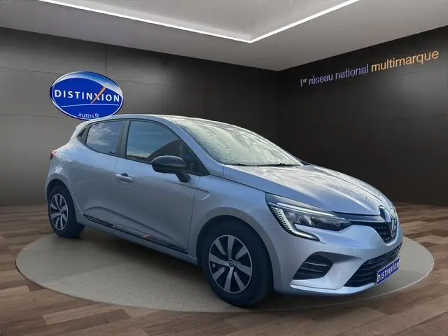 Renault Clio V TCE 90 Evolution gris Highland vue 3/4 avant droit avec vitres arrière surteintées et projecteurs LED