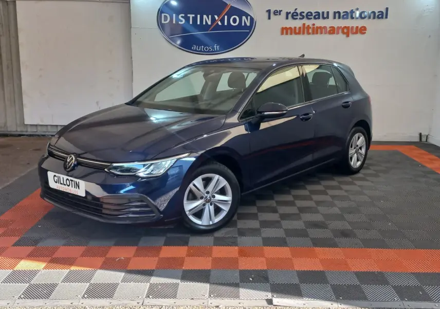 Volkswagen Golf bleu 2022 vue 3/4 avant droit, avec jantes alliage et calandre moderne dans showroom.