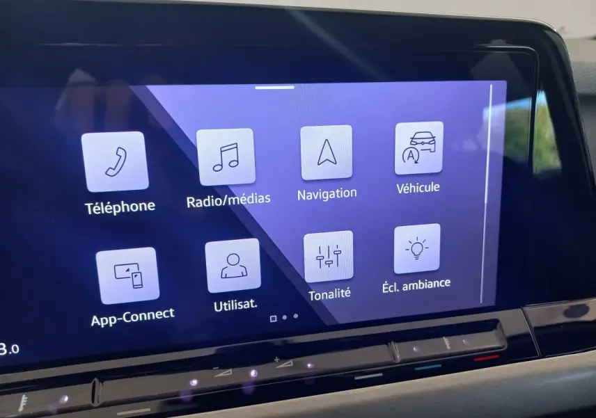 Écran tactile central de la Volkswagen Golf 1.5 bleu affichant les menus téléphone, navigation et ambiance lumineuse.