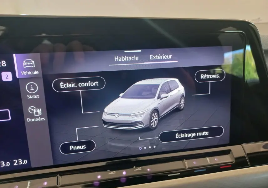 Écran tactile affichant une Volkswagen Golf blanche en vue 3/4 avant avec options éclairage et pneus détaillées.