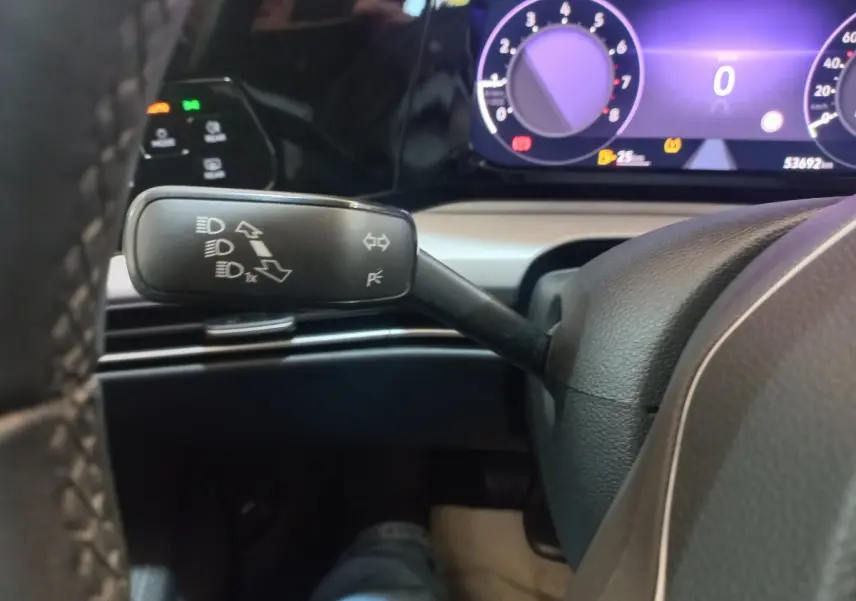 Gros plan sur la manette de clignotants à gauche du volant dans le tableau de bord numérique d'une Volkswagen Golf bleue 2022.