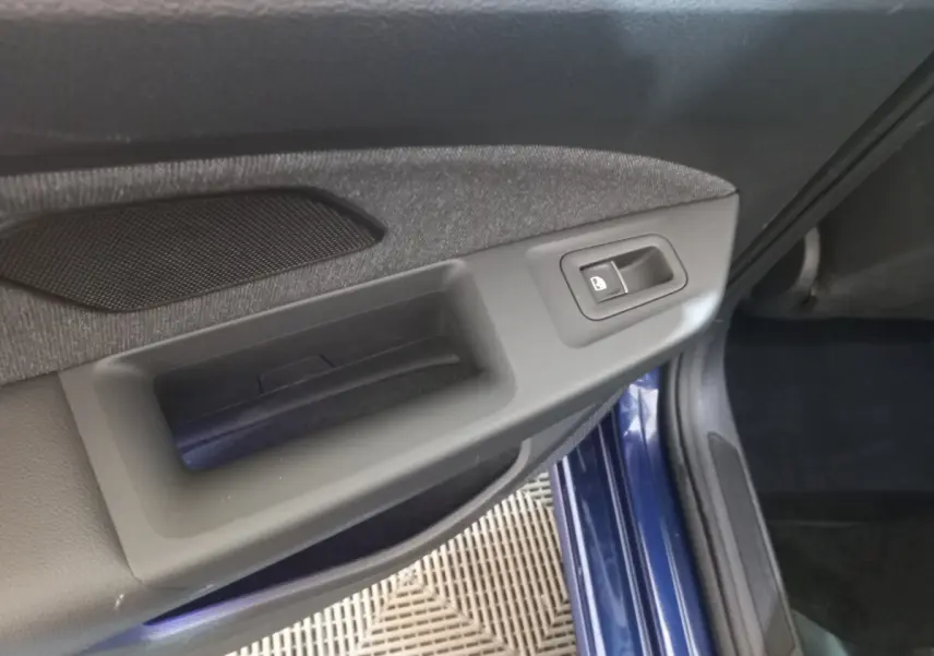 Détail de la poignée intérieure côté gauche avec bouton de verrouillage sur une Volkswagen Golf bleu 2022.
