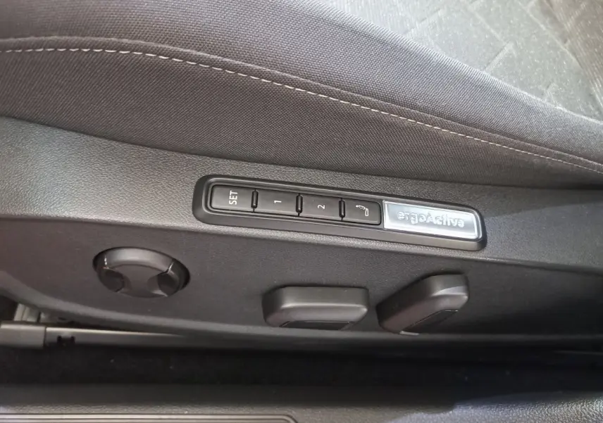 Détail des commandes de réglage de siège noir avec mémoire ergonomique ergoActive dans une Volkswagen Golf 2022.