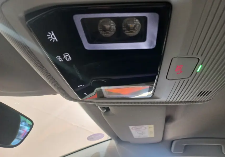 Vue rapprochée du plafonnier intérieur avec commandes lumineuses et bouton SOS de la Volkswagen Golf bleue 2022