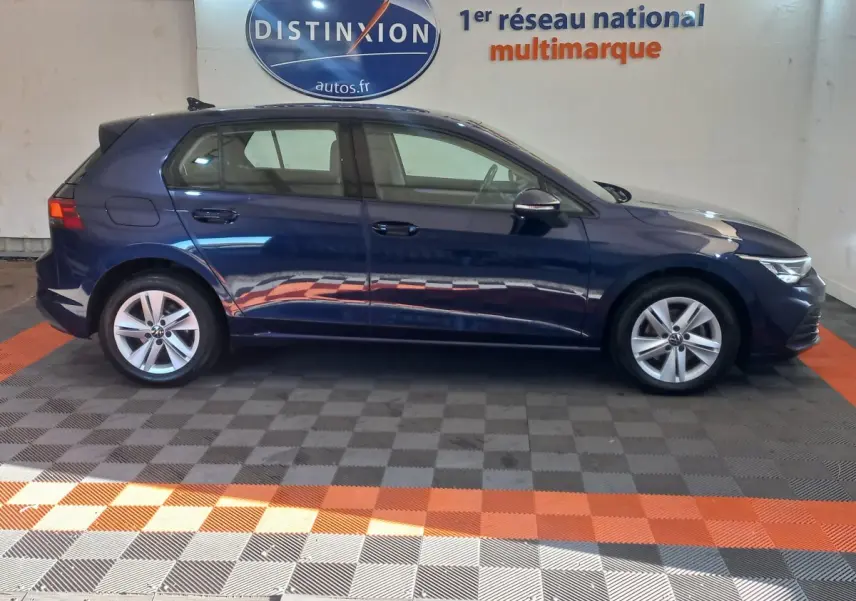Profil droit d'une Volkswagen Golf bleu 2022, avec jantes alliage et éclairage LED avant visible.
