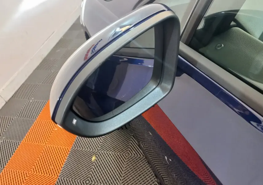 Gros plan sur le rétroviseur côté gauche bleu foncé de la Volkswagen Golf 2022 avec logo R-Line visible.