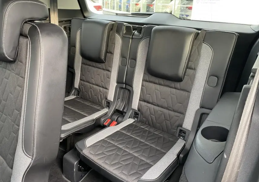 Vue intérieure sur les sièges arrière en cuir noir et tissu gris du Volkswagen Touran 2025, version 7 places.