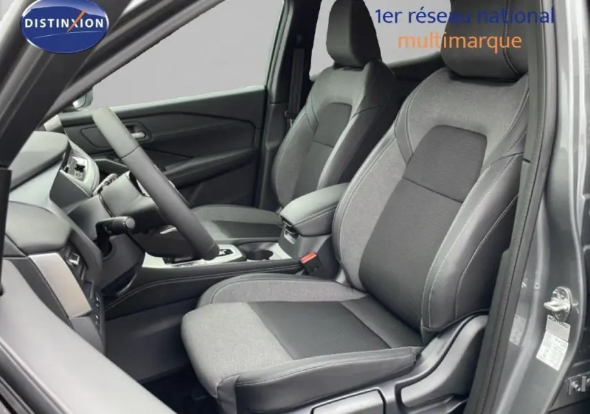 Vue intérieure côté conducteur du Nissan Qashqai gris 2025, mettant en valeur les sièges bi-matière et le volant multifonctions cuir.