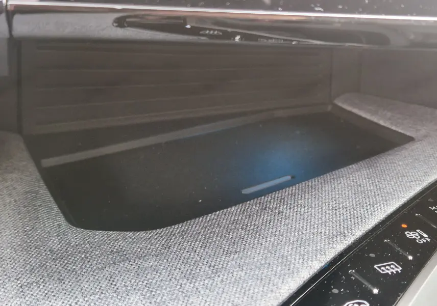 Détail du rangement central avec surface textile grise et commandes tactiles noires du Peugeot 3008 1.2 Hybrid 2025.