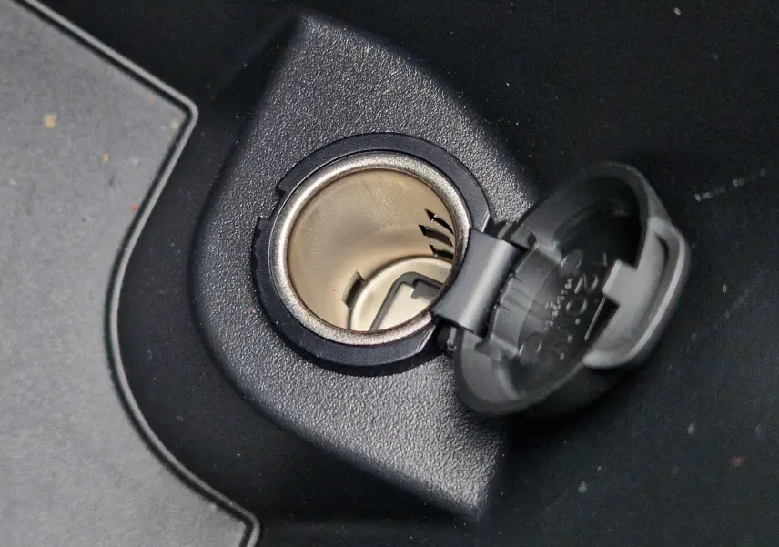 Gros plan sur la prise allume-cigare ouverte dans l’habitacle noir du Peugeot 3008 Gris Artense 2025.