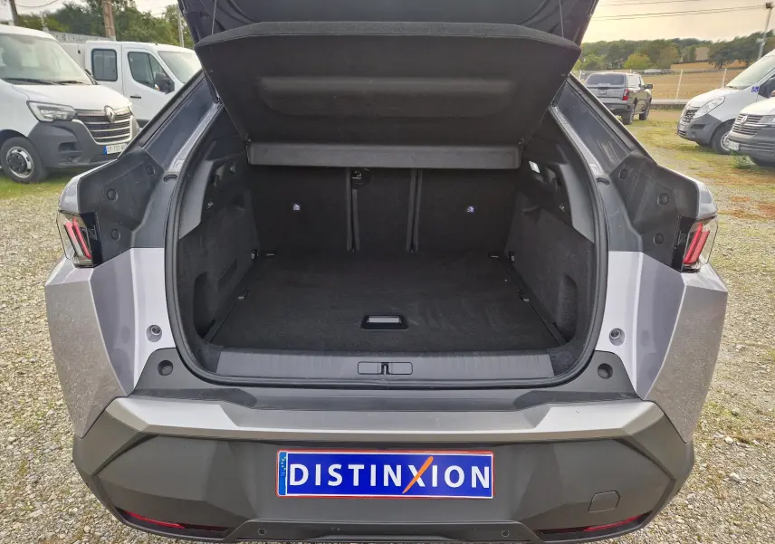 Coffre ouvert vu de l'arrière d'un Peugeot 3008 gris Artense 2025, soulignant l'espace de chargement vide.