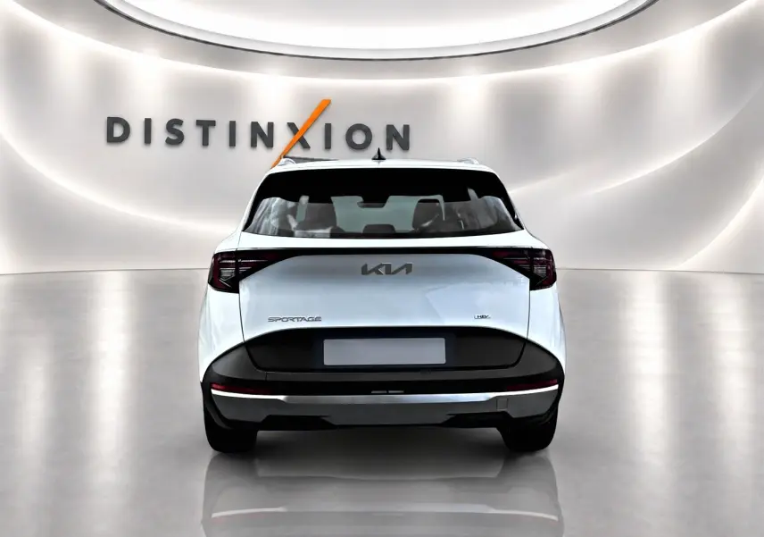 Vue arrière d’un KIA Sportage blanc 2026 avec feux arrière LED et logo central dans un showroom lumineux.