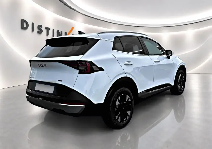 Vue 3/4 arrière droite d'un KIA Sportage blanc 2026 avec jantes noires et feux arrière LED distinctifs.