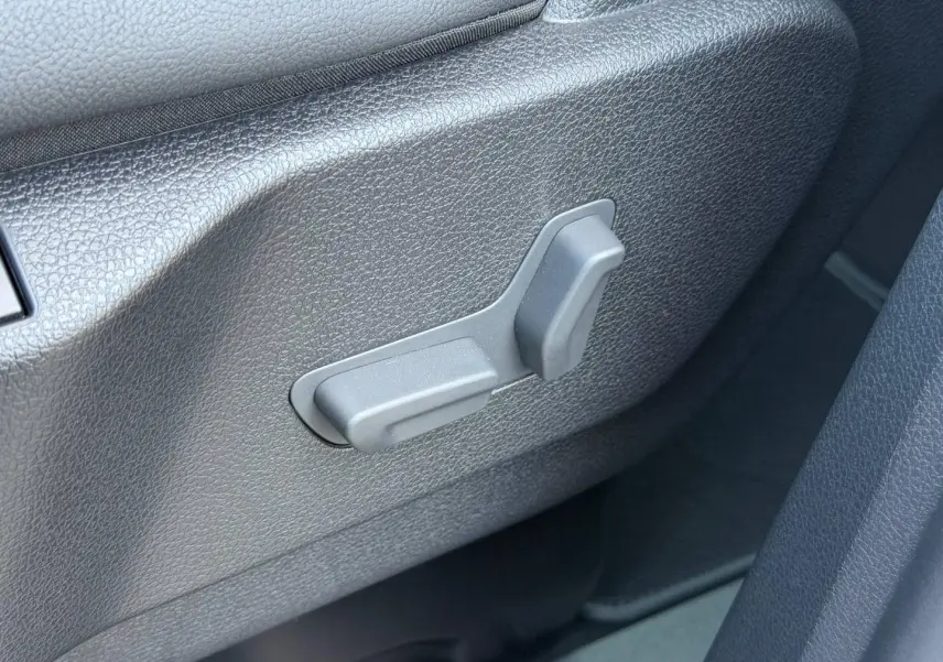 Détail des commandes de réglage manuel du siège avant en plastique gris dans un Citroën Spacetourer XL gris Titane.