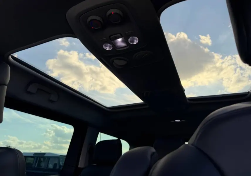 Vue intérieure du toit ouvrant panoramique du Citroën Spacetourer XL gris titane avec ciel nuageux visible.