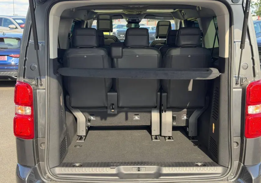 Vue arrière ouverte du Citroën Spacetourer XL gris titane montrant le coffre et la troisième rangée de sièges en tissu bi-ton noir/gris.