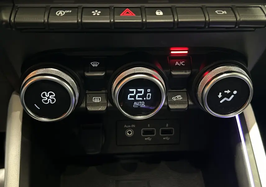 Gros plan sur les commandes de climatisation de la Renault Clio V TCe 90 TECHNO gris, avec affichage digital à 22°C et bouton A/C activé.