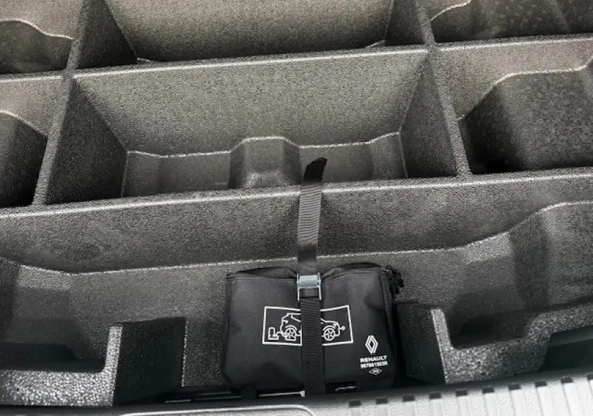 Rangement de coffre noir étoilé avec trousse d'urgence Renault attachée par sangle.