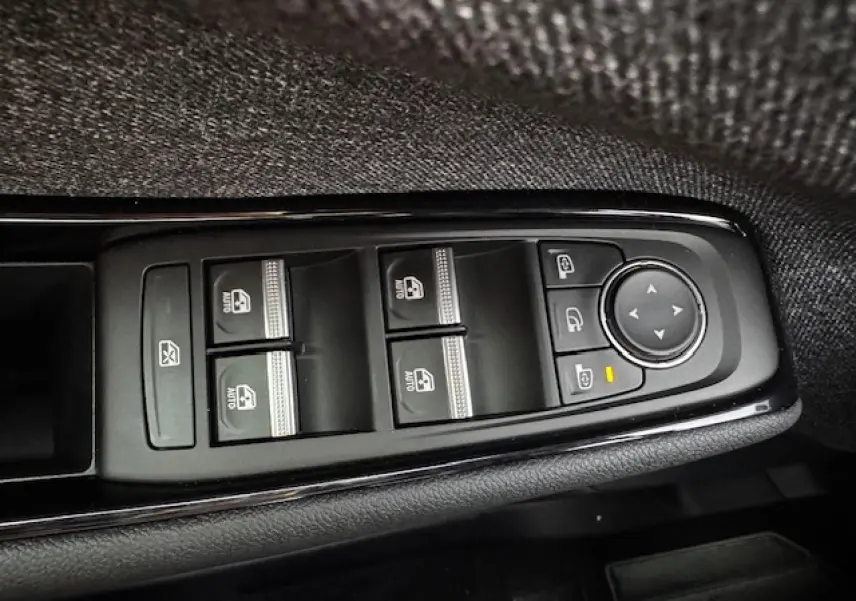 Gros plan sur les commandes de lève-vitres et rétroviseurs côté conducteur du Renault Espace VI noir étoilé.