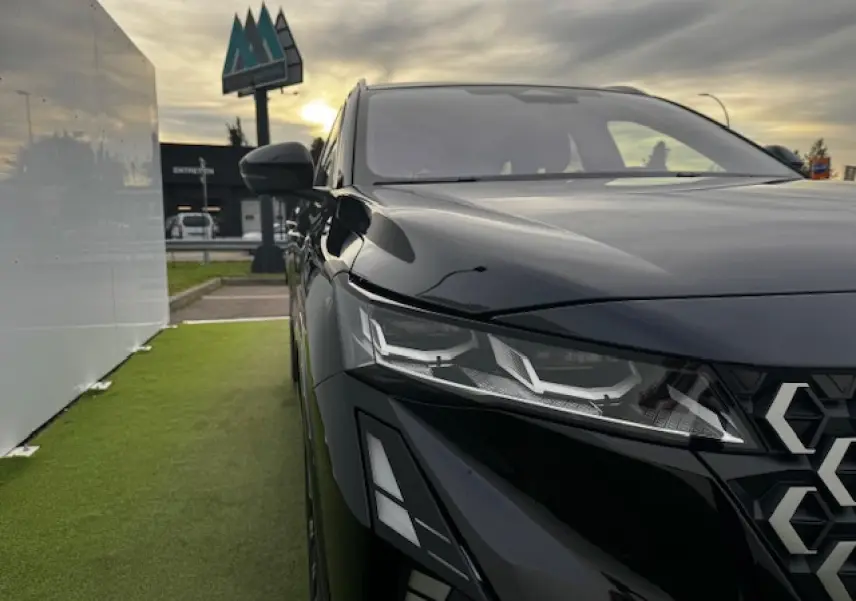 Gros plan sur l'avant droit du Renault Espace noir étoilé, mettant en valeur ses phares LED et la calandre gris chrome satin.