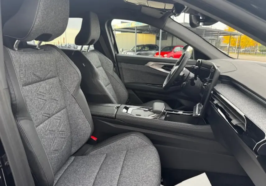 Vue intérieure côté conducteur du Renault Espace VI 1.2 Full Hybrid 2025 avec sièges textile gris et console centrale noire.