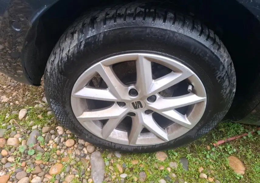 Gros plan sur la roue avant gauche d'une SEAT LEON gris 2021, avec jante alliage à cinq branches doubles.